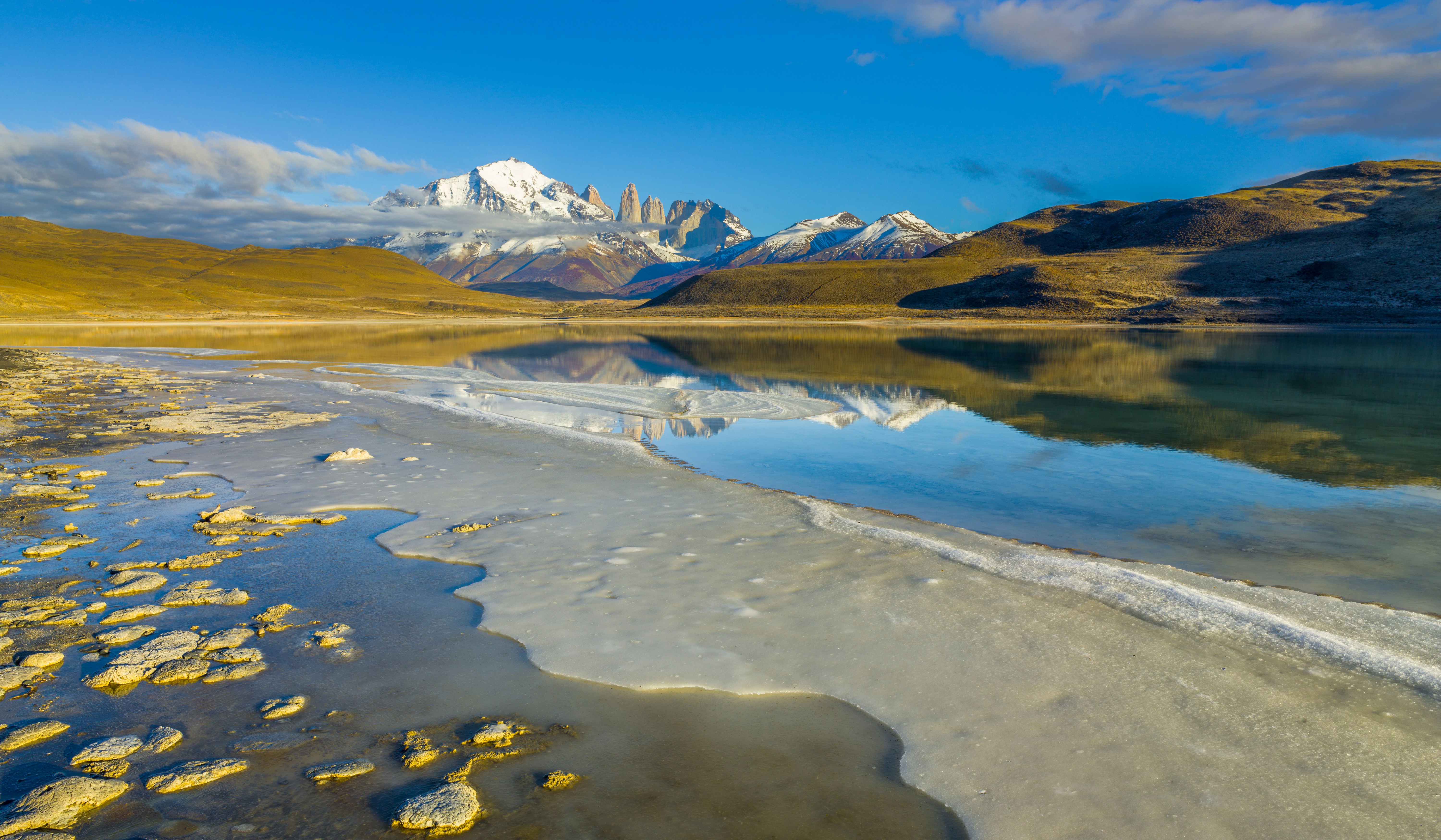 lake near mountain under blue sky during daytime